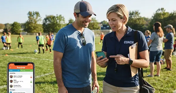 Youth sports coach and parent reviewing a team communication app together